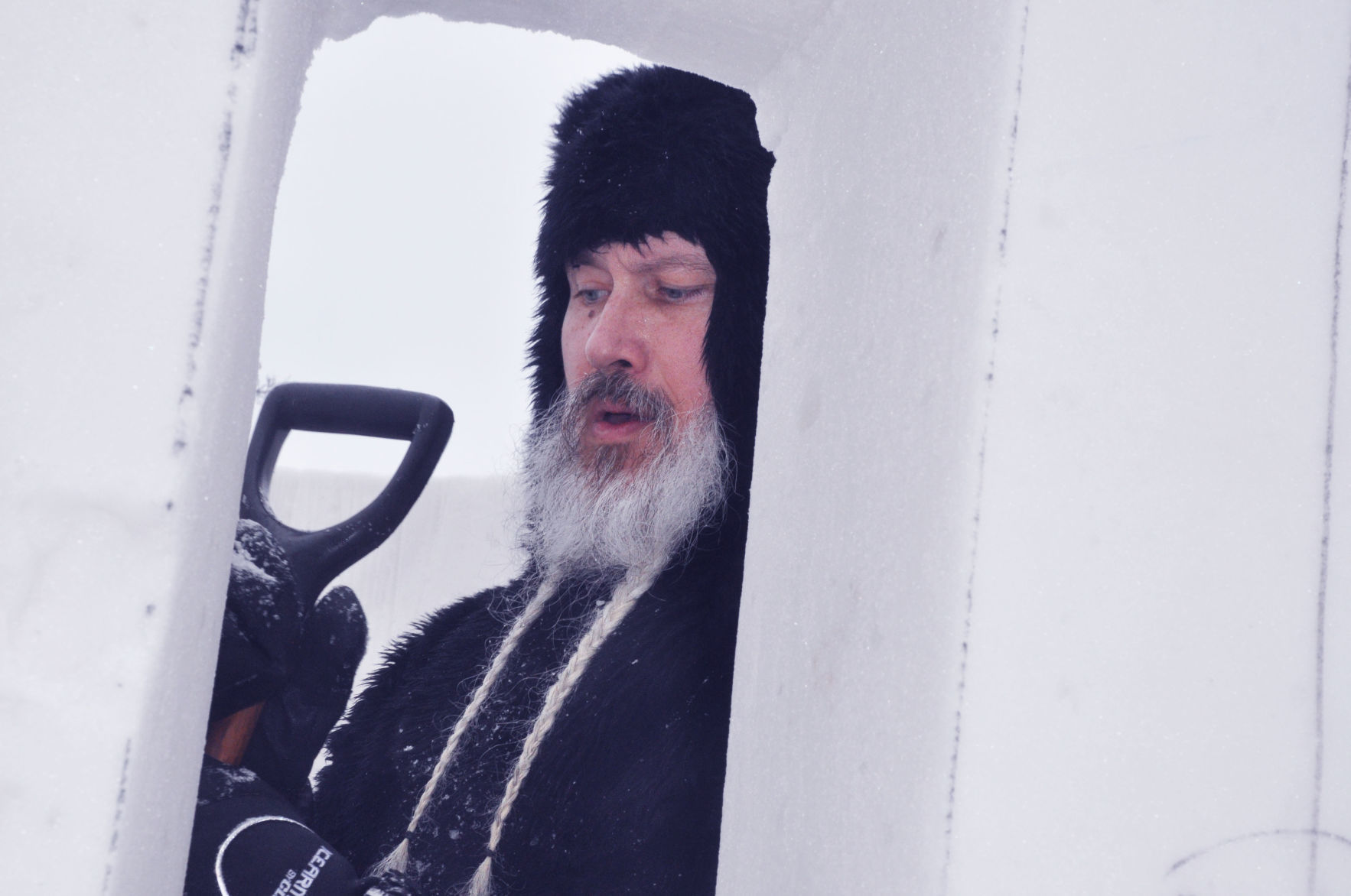 Bear outfit sculptor works on interior of snow sculpture